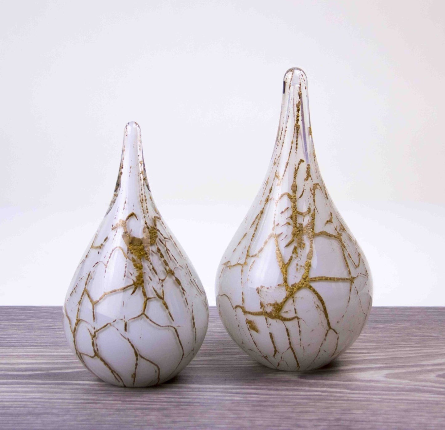 Druppelvormige handgemaakte urn van glas in de kleur wit met bladgoud