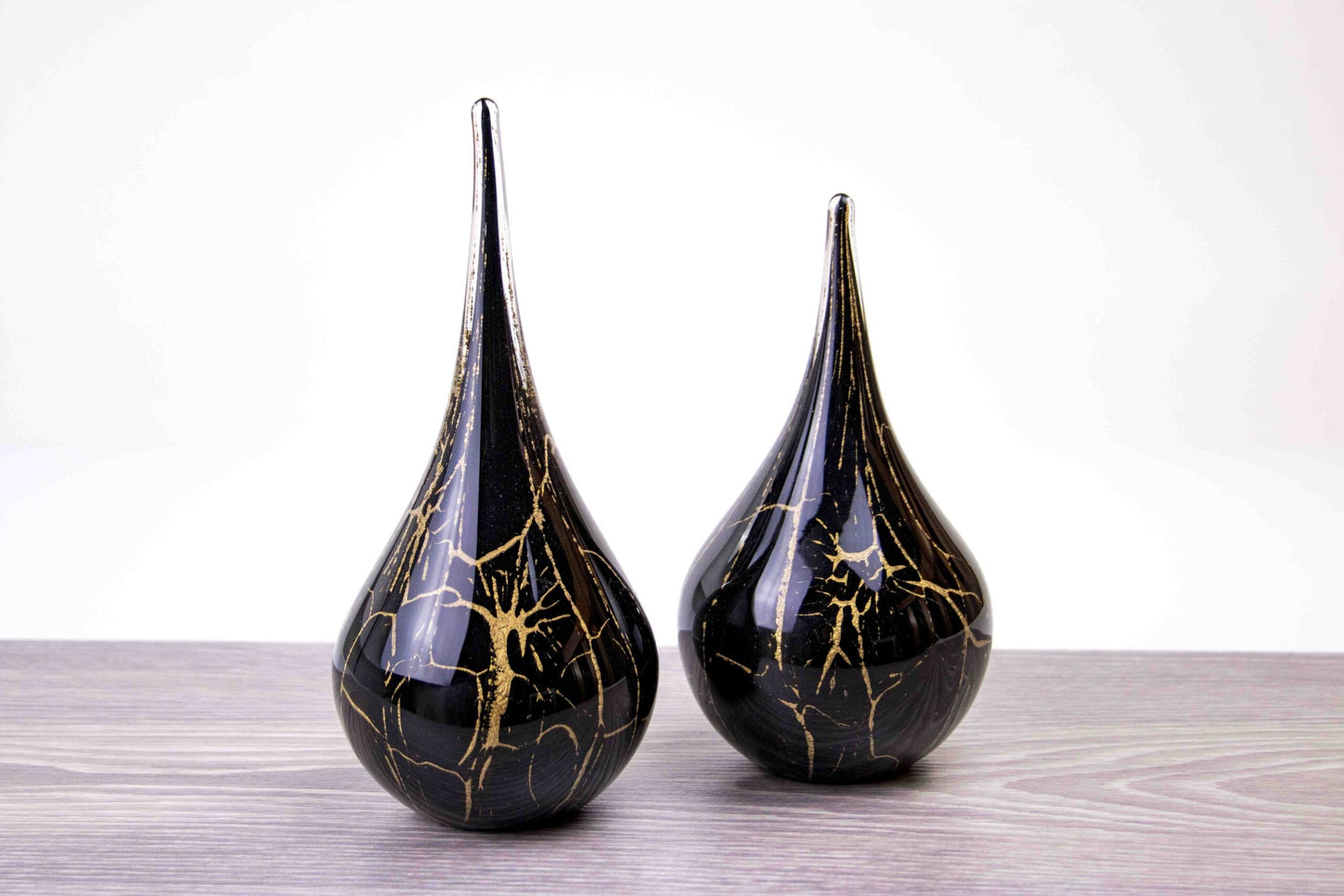 Druppelvormige handgemaakte urn van glas in de kleur zwart met bladgoud