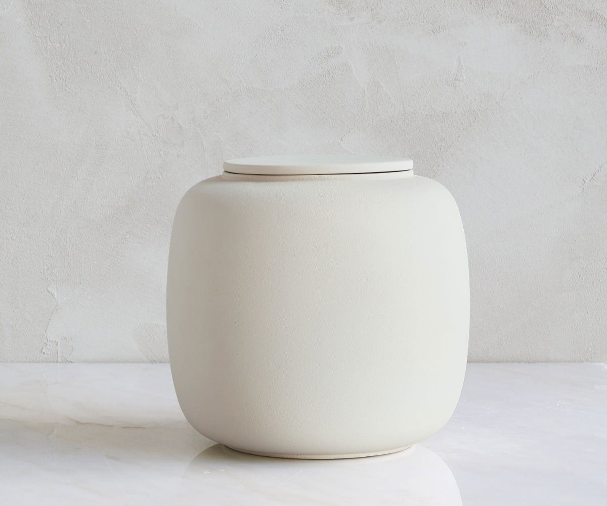 Seres cilindervormige handgemaakte biologisch afbreekbare urn van keramiek in de kleur beige