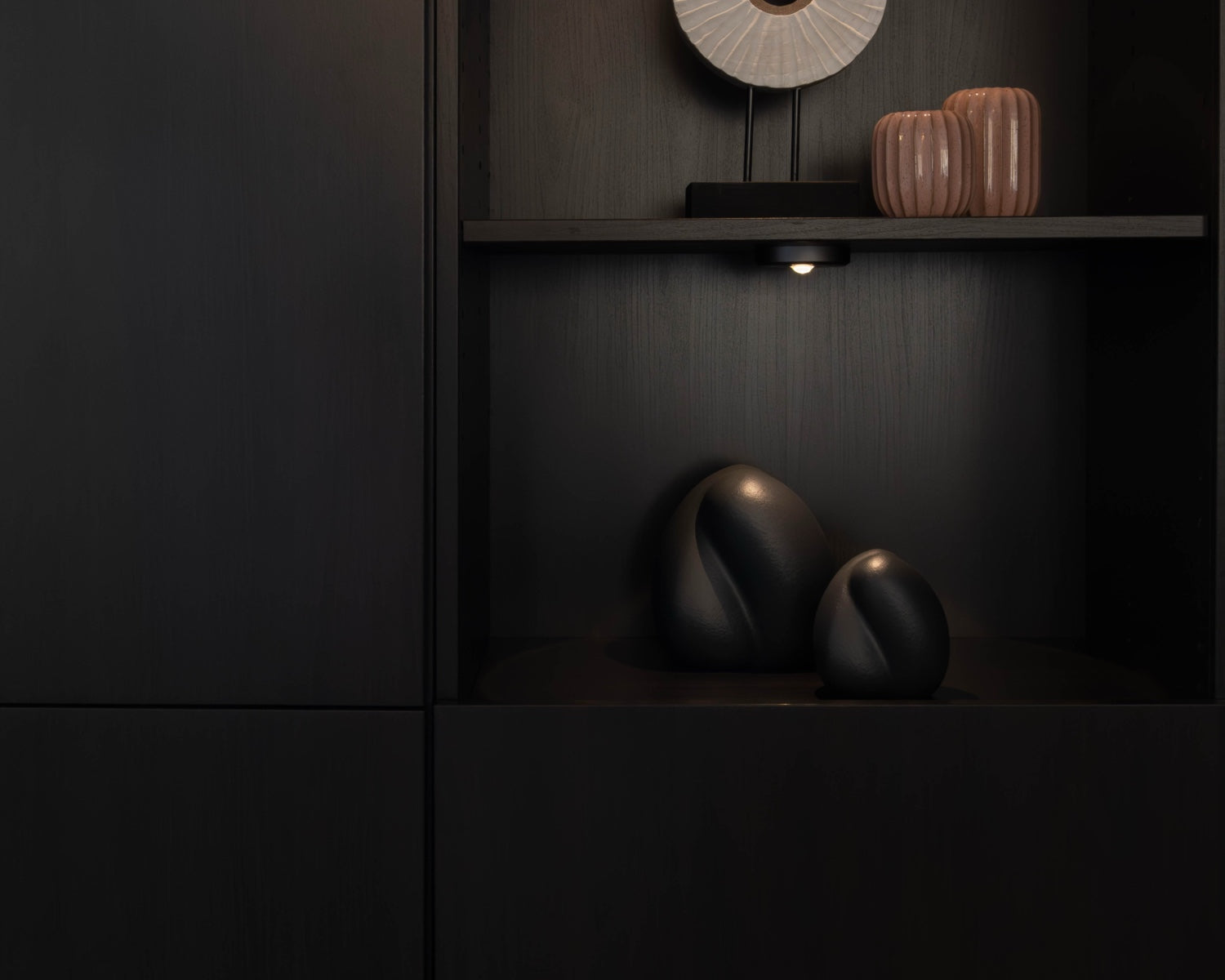 Sfeerfoto van de kleine donkerblauwe Embrace urn in een kast – modern Nederlands design