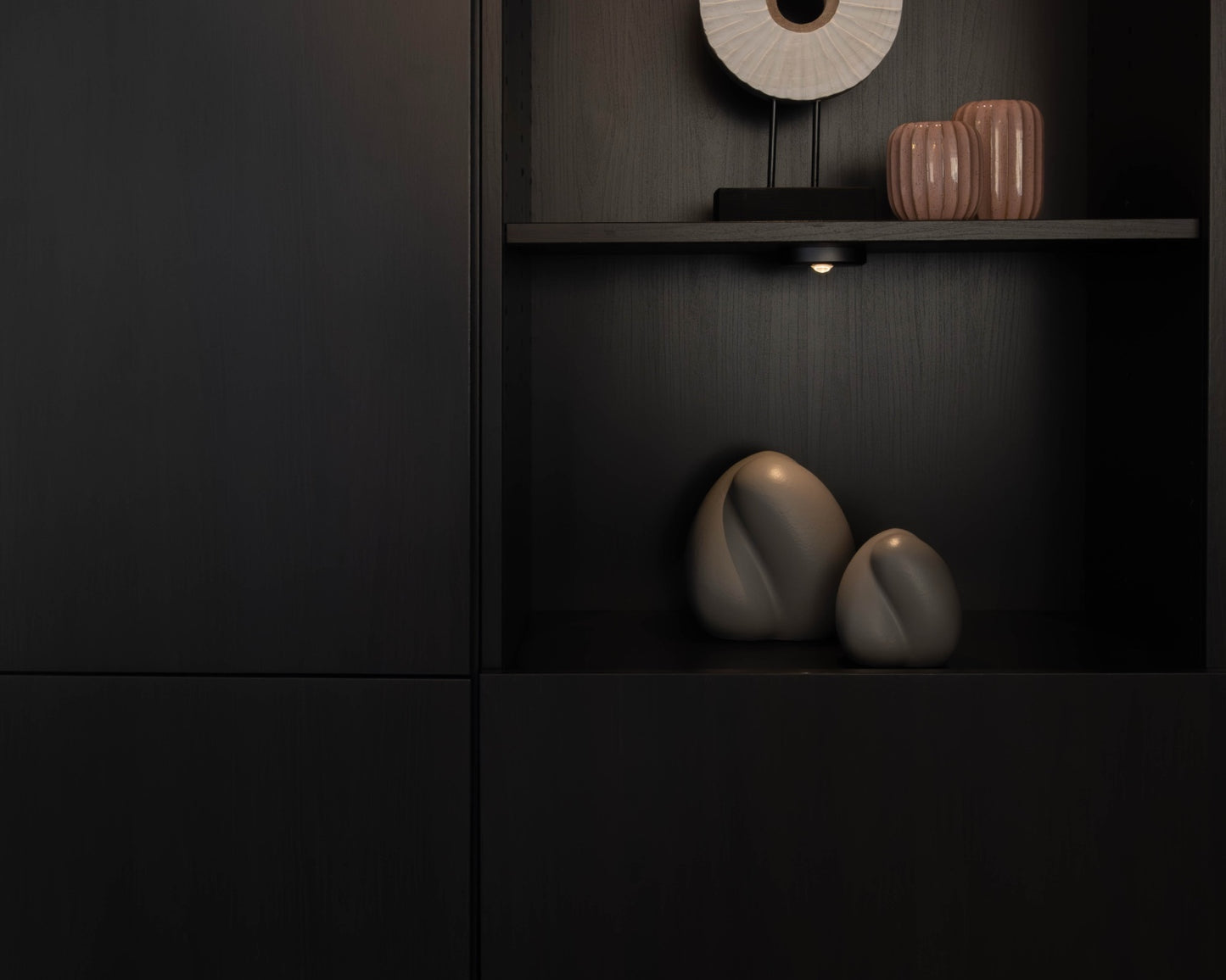 Sfeerfoto van de kleine grijze Embrace urn in een kast – modern Nederlands design