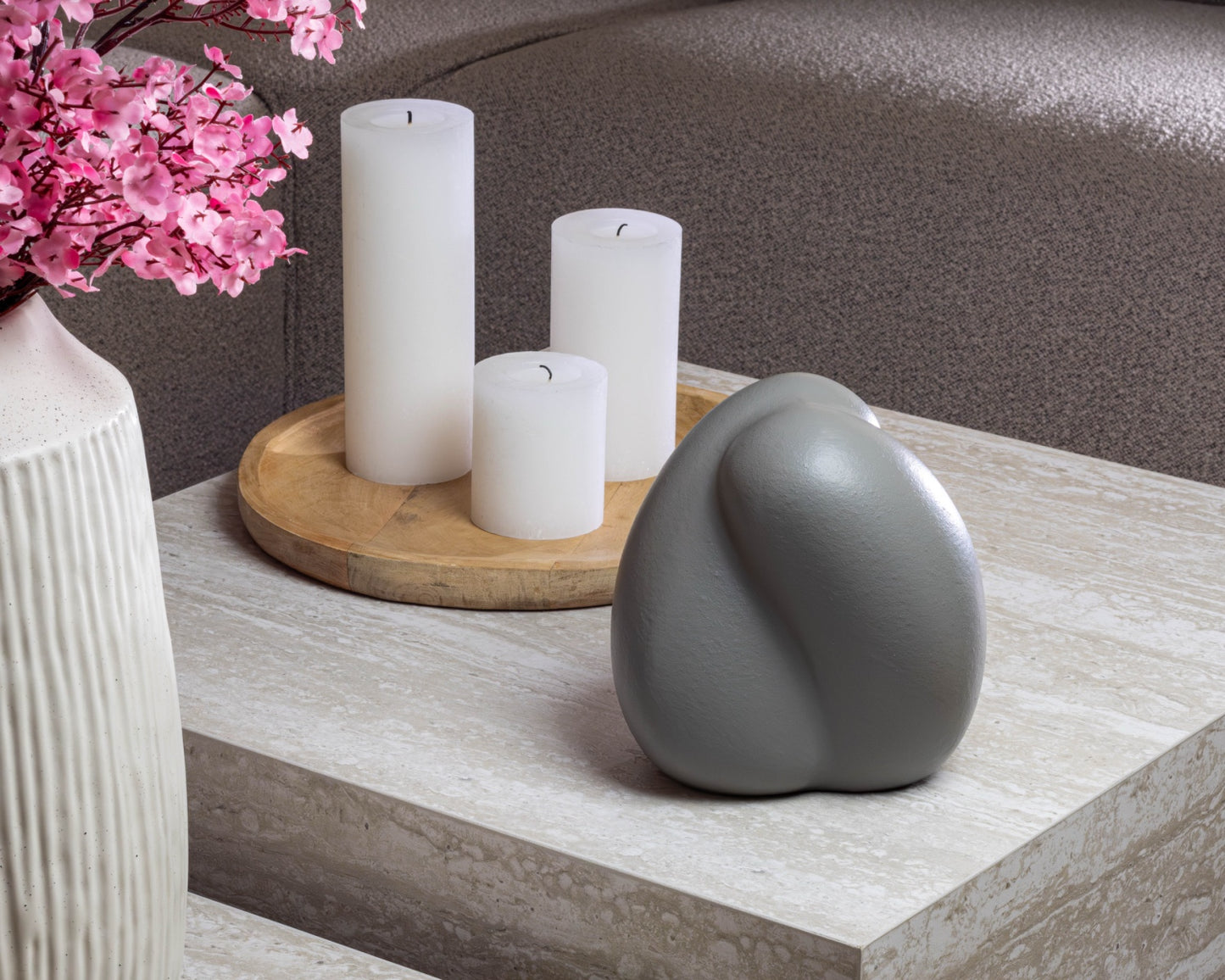 Sfeerfoto van de kleine grijze Embrace urn op een tafel – modern Nederlands design