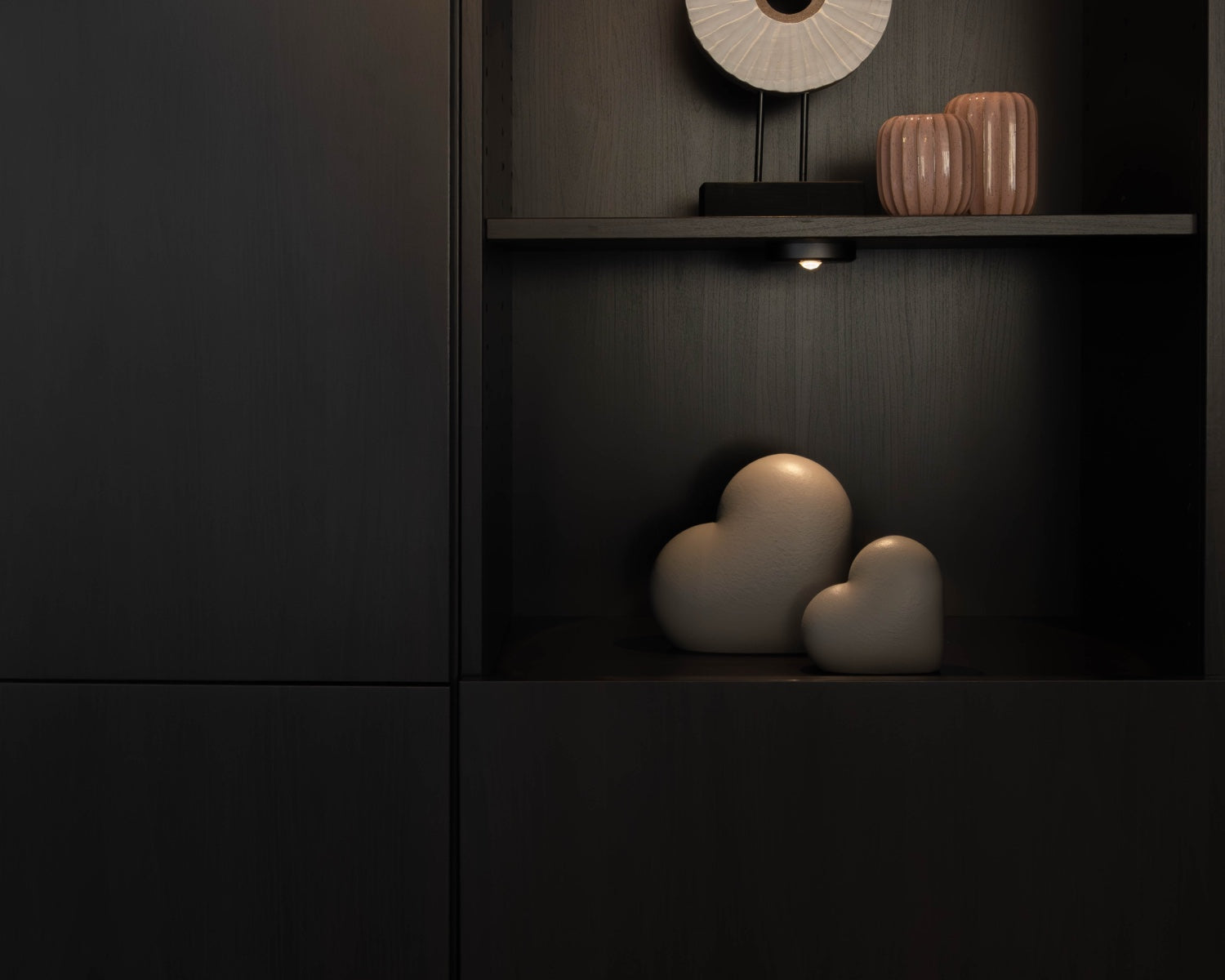Sfeerfoto van de kleine grijze Heart urn in een kast – modern Nederlands design