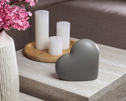 Sfeerfoto van de kleine grijze Heart urn op een tafel – modern Nederlands design